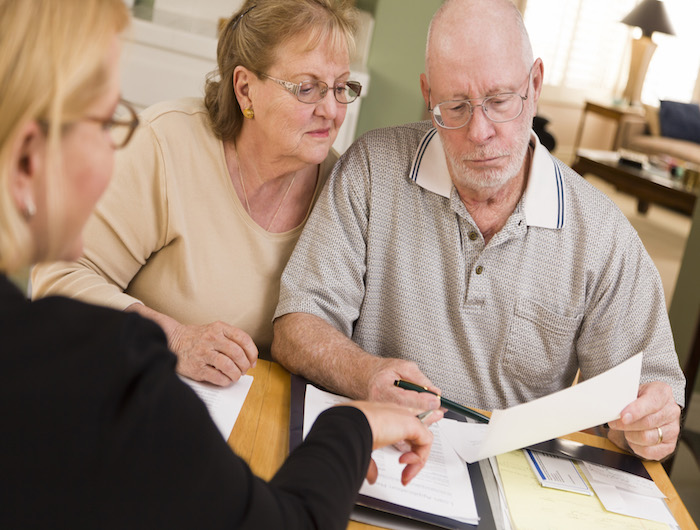 Senior Adult Couple Going Over Papers in Home with Agent